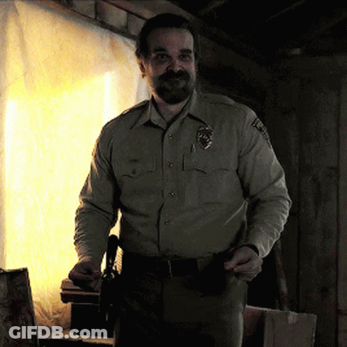 Man In Sheriff Uniform Holding Gun In Pocket GIF