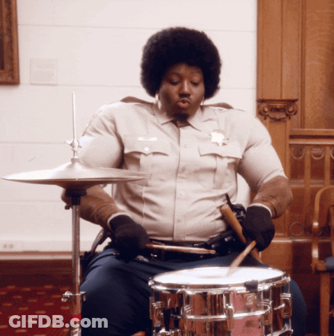 Man In Sheriff Uniform Playing Drum Set GIF