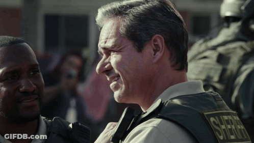 Man In Sheriff Vest Smiling Talking To Another Man GIF