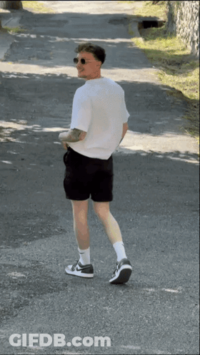 Man In Shorts And White Shirt Walking GIF