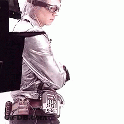 Man In Silver Jacket And Goggles Holding Gun With Arms Crossed GIF