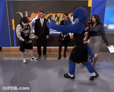 Man In Sixers Jersey Standing In Front Of 76Ers Sign GIF