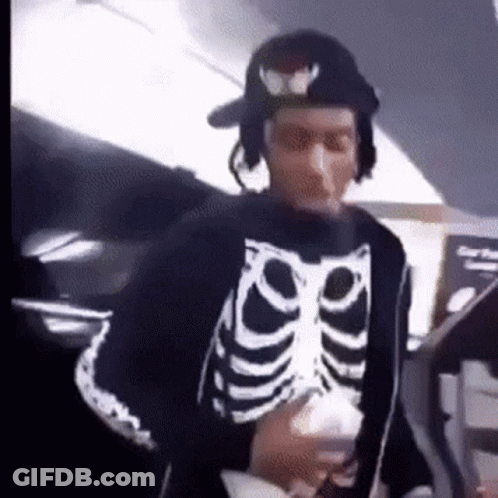 Man In Skeleton Sweater And Hat Holding Cup GIF