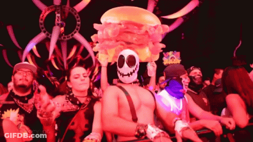 Man In Skull Mask Holding Inflatable Hamburger On Head GIF