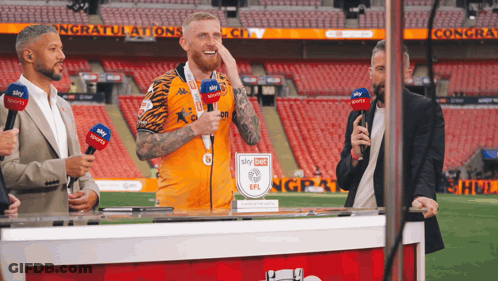 Man In Sky Sports Jersey Behind Table GIF