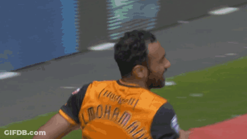 Man In Soccer Uniform Running On Red Field GIF