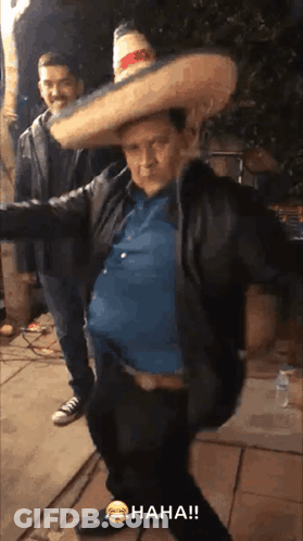 Man In Sombrero Standing Next To Man In Jacket GIF