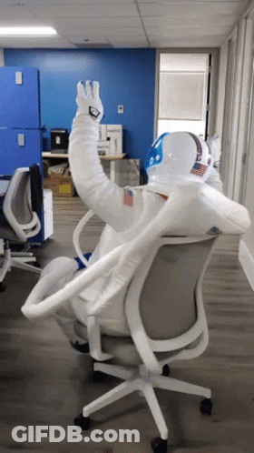 Man In Space Suit Sitting In Chair GIF