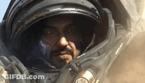 Man In Space Suit With Helmet Looking At Camera GIF