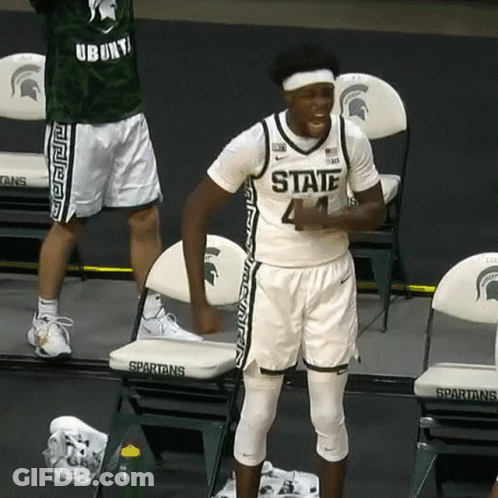Man In Spartans Jersey Standing Before Chairs GIF