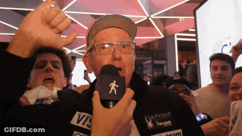Man In Spyder Jacket Holding Microphone Before Crowd GIF