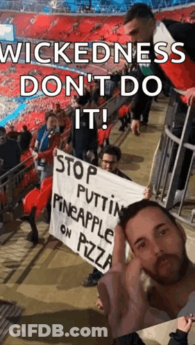 Man In Stadium Holding Wickedness Sign GIF