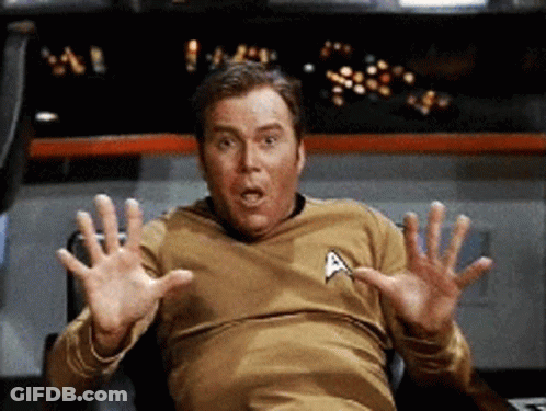 Man In Star Trek Shirt Sitting With Outstretched Hands GIF