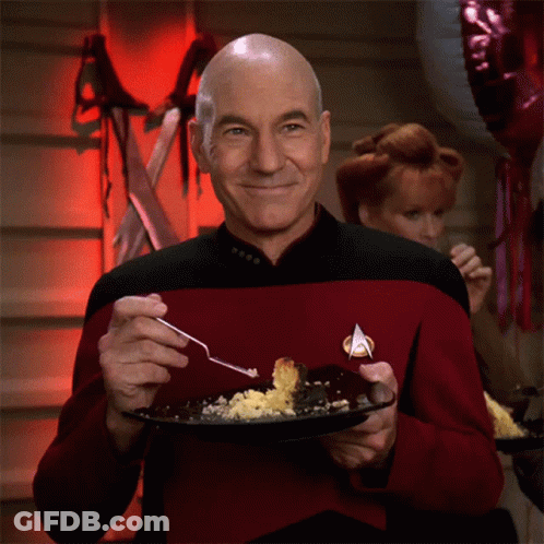 Man In Star Trek Uniform Holding Plate Of Food With Fork GIF