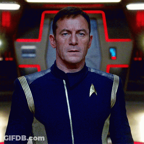 Man In Star Trek Uniform In Front Of Red Light GIF