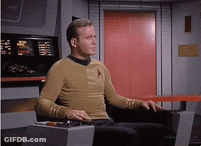 Man In Star Trek Uniform Sitting In Front Of Red Door GIF