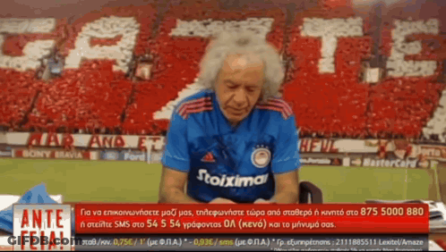 Man In Stoixima Shirt Talking On Phone GIF