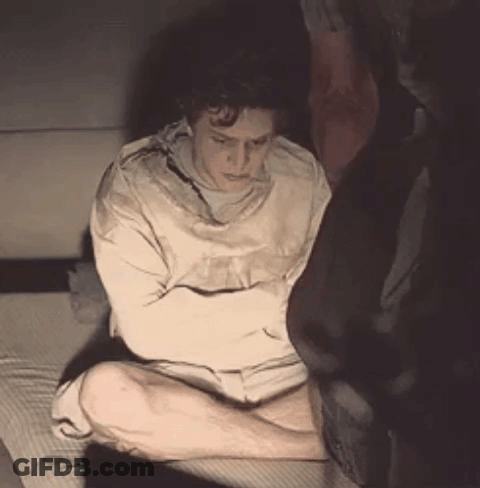 Man In Straight Jacket Sitting With Arms Crossed GIF