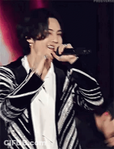 Man In Striped Jacket Singing Into Microphone GIF