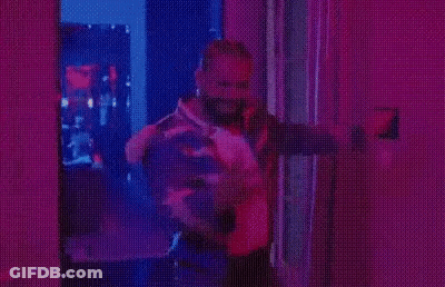 Man In Striped Jacket Under Purple Lights GIF