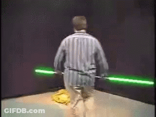 Man In Striped Pajamas Holding Green Lightsabers GIF
