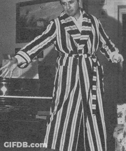 Man In Striped Robe Holding Broom GIF
