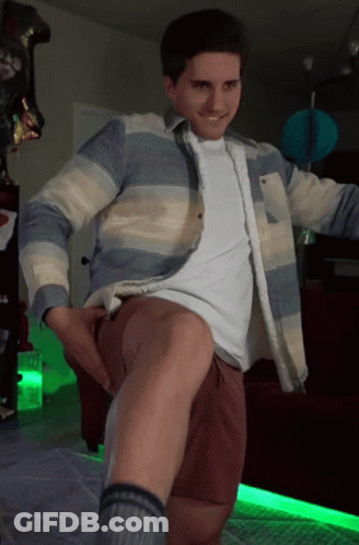 Man In Striped Shirt And Brown Shorts Standing With Leg Up GIF