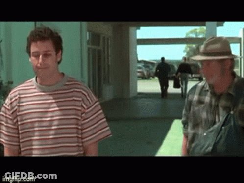 Man In Striped Shirt And Man In Hat Standing In Hallway GIF