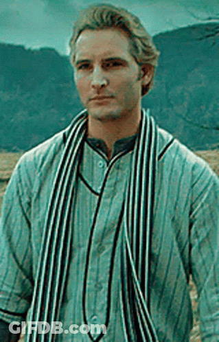 Man In Striped Shirt And Scarf Standing In Front Of Mountain GIF
