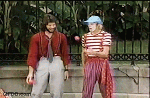 Man In Striped Shirt And Suspenders Standing Next To Another Man GIF