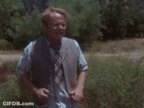 Man In Striped Shirt And Tie Running In Field GIF