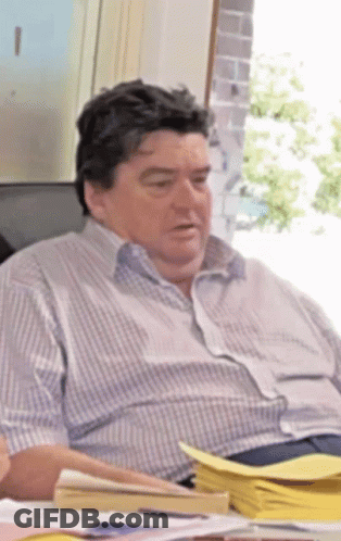 Man In Striped Shirt At Desk With Papers GIF