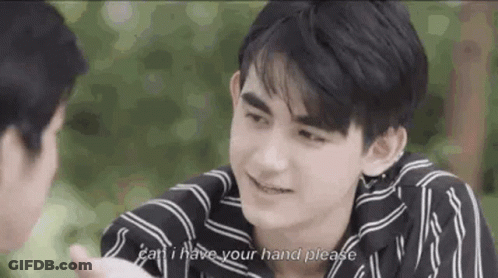 Man In Striped Shirt Holding Another Man's Hand And Talking GIF