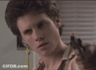 Man In Striped Shirt Holding Gun To Ear GIF