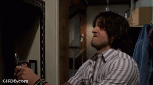 Man In Striped Shirt Holding Scissors GIF
