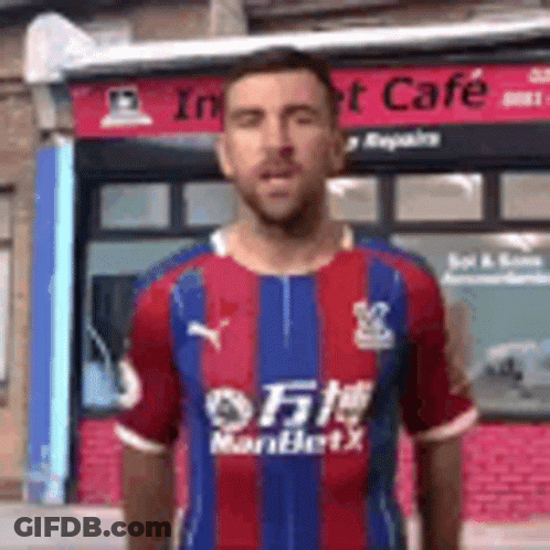 Man In Striped Shirt In Front Of Building GIF