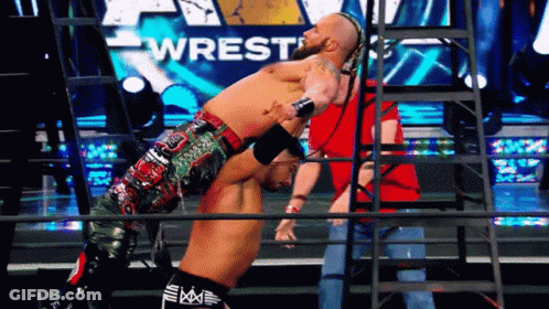 Man In Striped Shirt In Front Of WWE Screen GIF