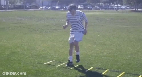 Man In Striped Shirt Jumping Over Ladder GIF