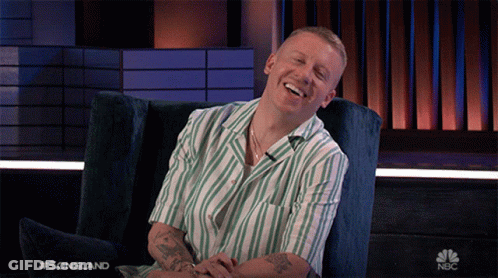 Man In Striped Shirt Laughing With NBC Logo GIF