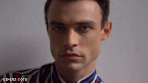 Man In Striped Shirt Looking At Camera GIF