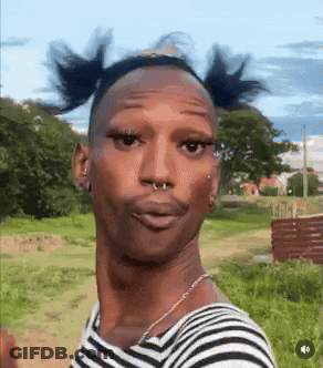 Man In Striped Shirt Making Funny Face In Field GIF