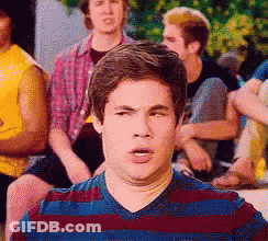 Man In Striped Shirt Making Funny Face To Group GIF