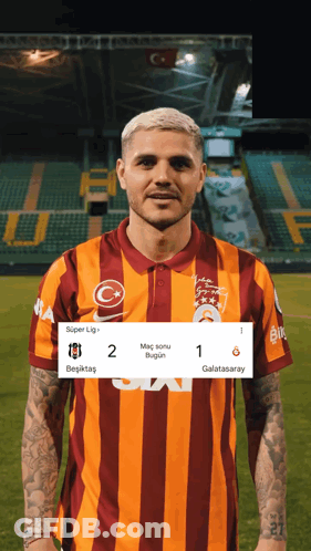 Man In Striped Shirt On Soccer Field With Scoreboard GIF