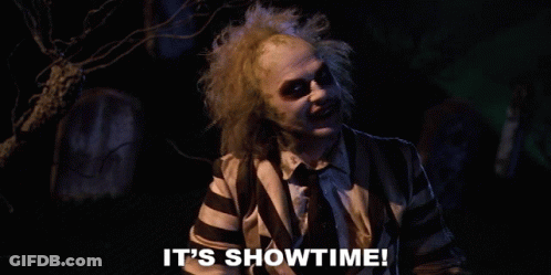 Man In Striped Shirt Says It's Showtime In Front Of Cemetery GIF
