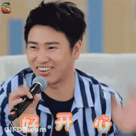 Man In Striped Shirt Singing Into Microphone Smiling GIF
