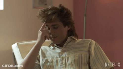 Man In Striped Shirt Sitting Before Netflix Wall GIF
