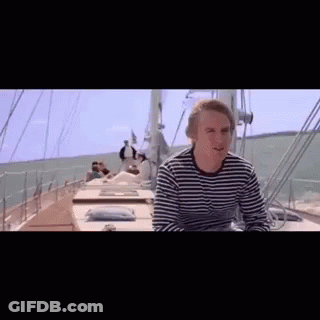 Man In Striped Shirt Sitting On Boat In Ocean GIF