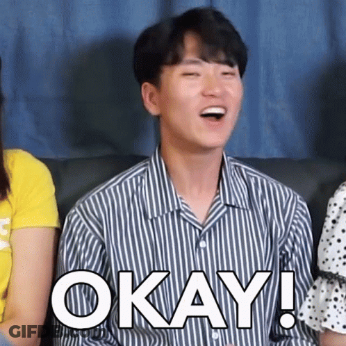 Man In Striped Shirt Sitting On Couch Saying Okay GIF
