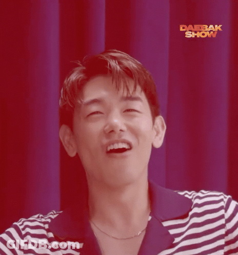 Man In Striped Shirt Smiling In Front Of Red Curtain Saying Daebak Show GIF