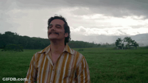 Man In Striped Shirt Standing In Field GIF